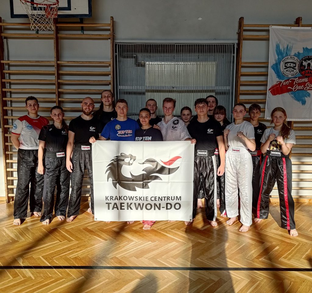 Zawodnicy Krakowskiego Centrum Taekwon-do pozują z flagą KCT wraz z trenerami z Włoch